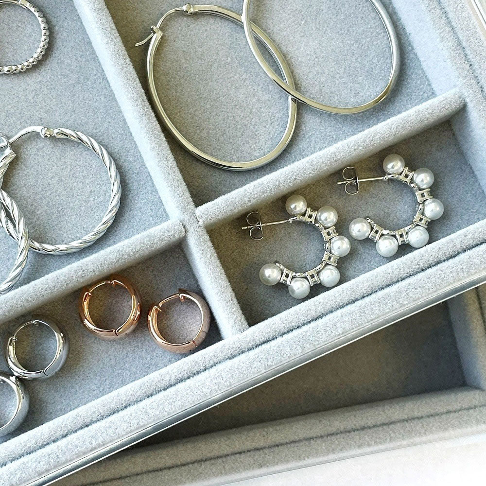 Flatlay view of Dome CZ Small Huggie Earrings in Sterling Silver 0.6 inch, Rhodium Plated