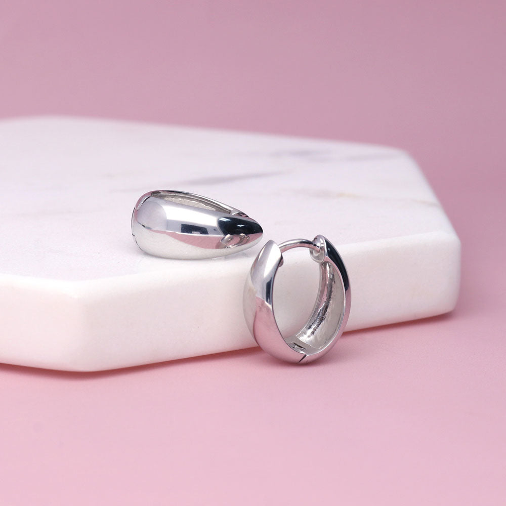 Flatlay view of Oval Dome Small Huggie Earrings in Sterling Silver 0.6 inch, Yellow Gold Flashed