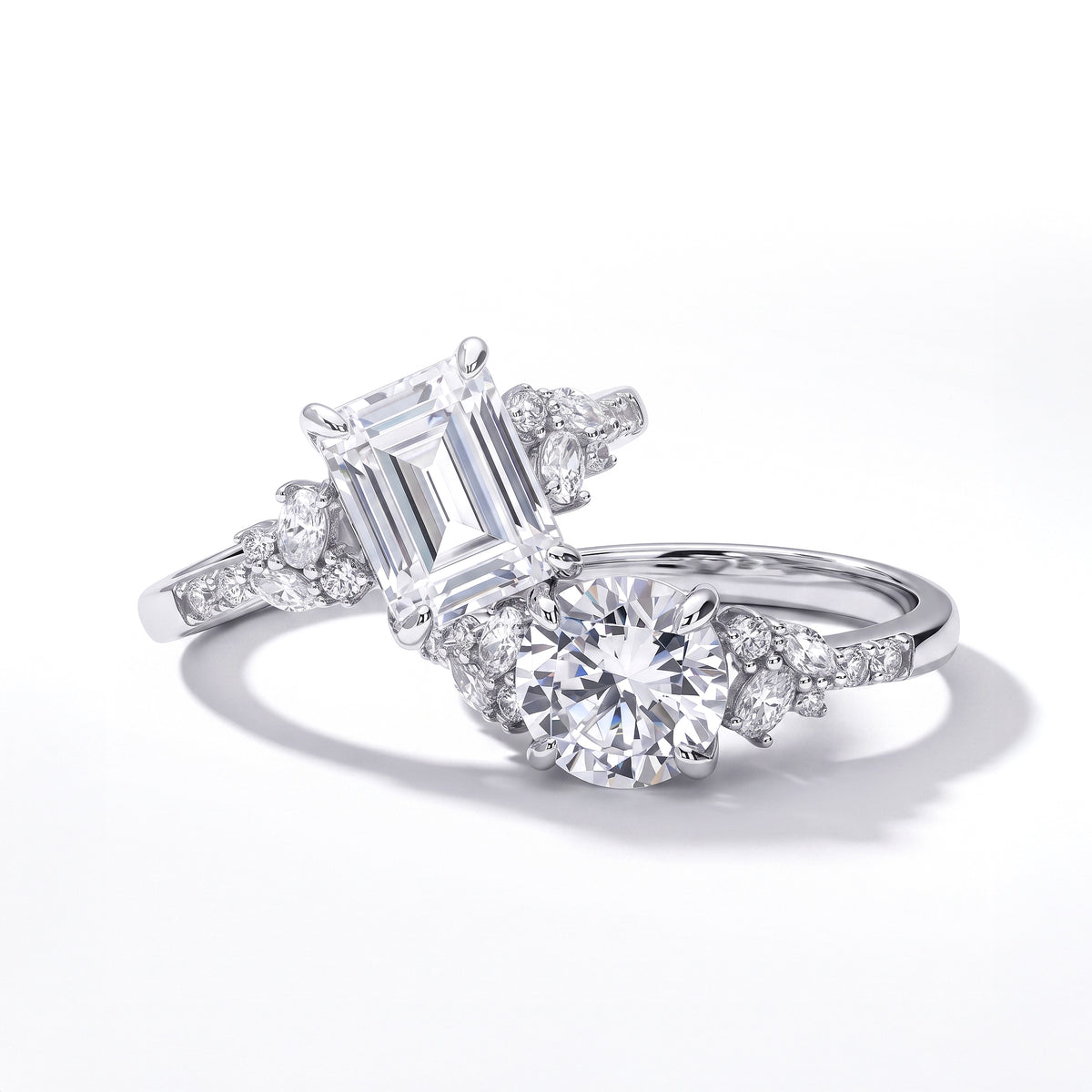 Silver CZ rings with emerald-cut and round center stones accented by sparkling floral side details.