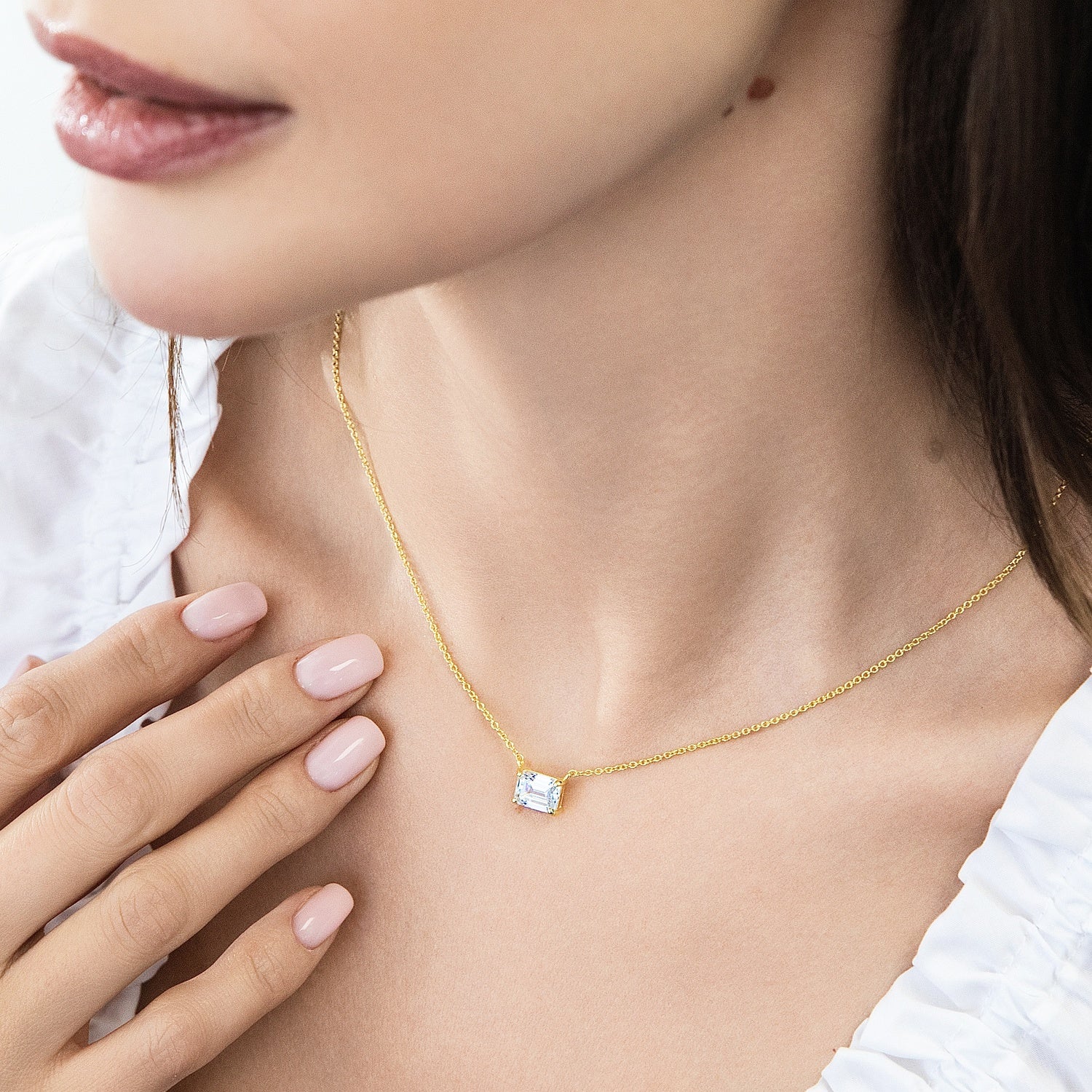 Model wearing Solitaire East-West Emerald Cut CZ Necklace in Sterling Silver, Gold Flashed