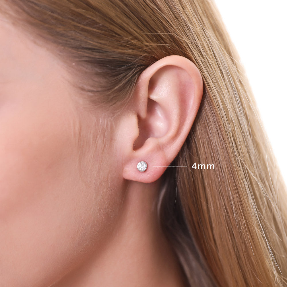 Model wearing Martini Solitaire Bezel CZ Stud Earrings, Rhodium Plated, Clear / 4mm