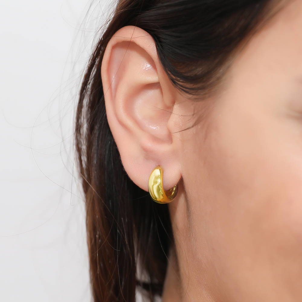 Model wearing Dome CZ Small Huggie Earrings in Sterling Silver 0.6 inch, Yellow Gold Flashed