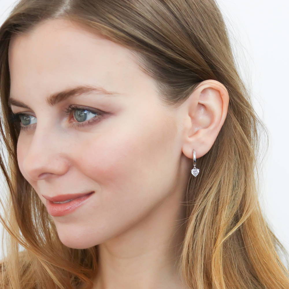Model wearing Solitaire CZ Cartilage Huggie Earrings in Sterling Silver 0.5 inch, Rhodium Plated / Heart Shaped Cut