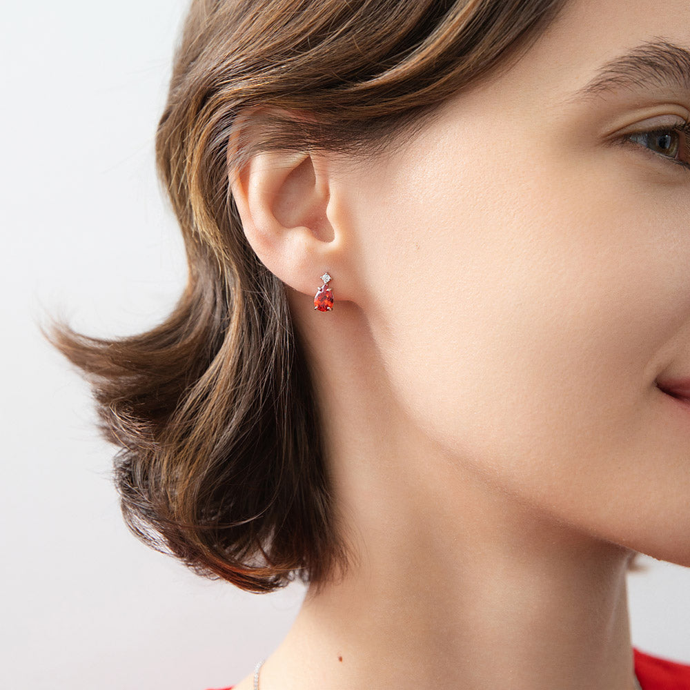 Model wearing Solitaire 2-Stone 1.4ct Pear CZ Stud Earrings in Sterling Silver, Garnet Color
