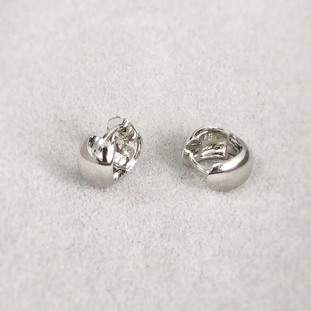 Flatlay view of Dome Mini Huggie Earrings in Sterling Silver 0.5 inch, Rhodium Plated