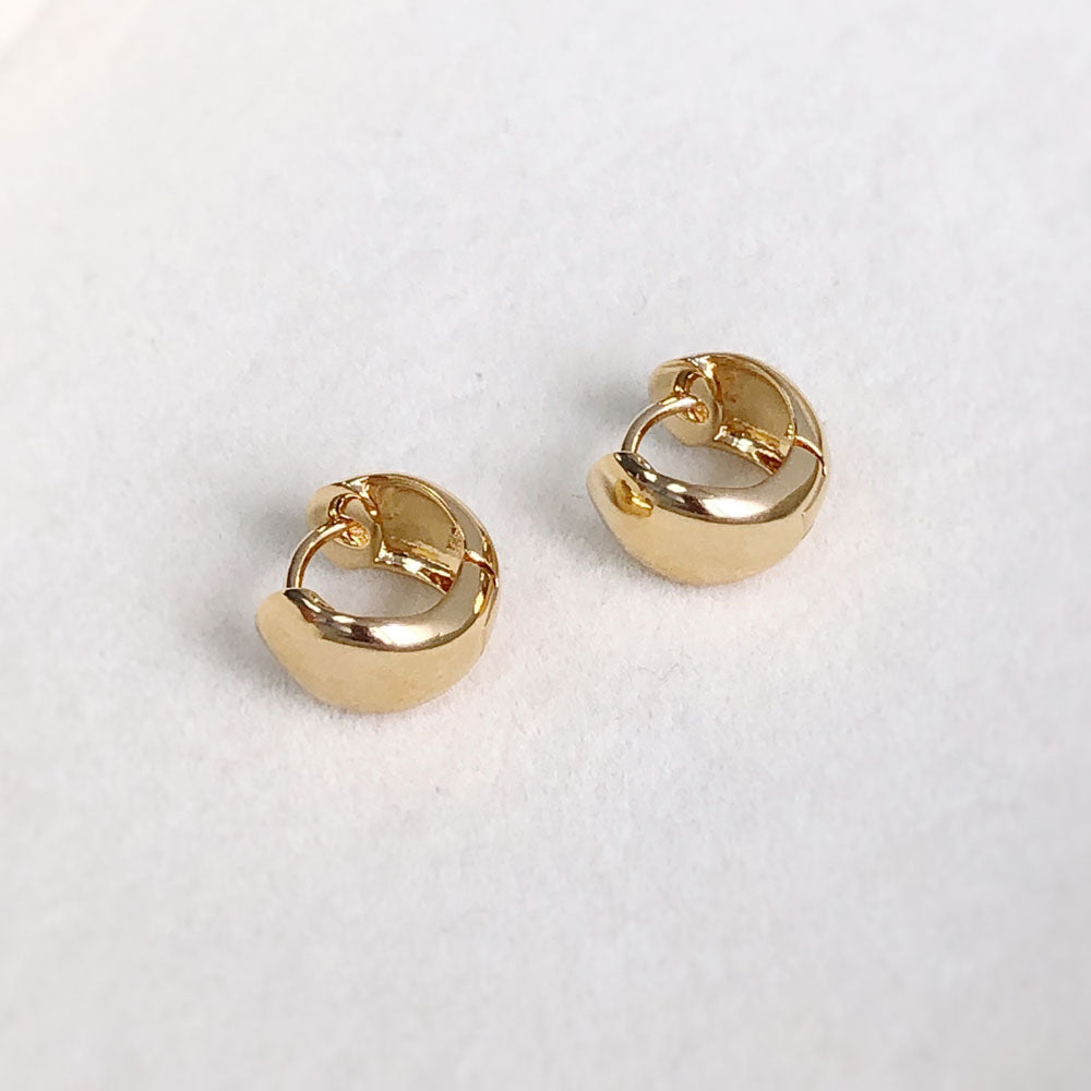 Flatlay view of Dome Mini Huggie Earrings in Sterling Silver 0.5 inch, Rhodium Plated