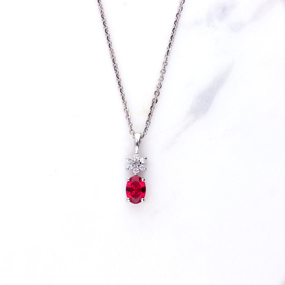 Flatlay view of Flower Simulated Ruby CZ Necklace and Earrings Set in Sterling Silver, 6 of 10