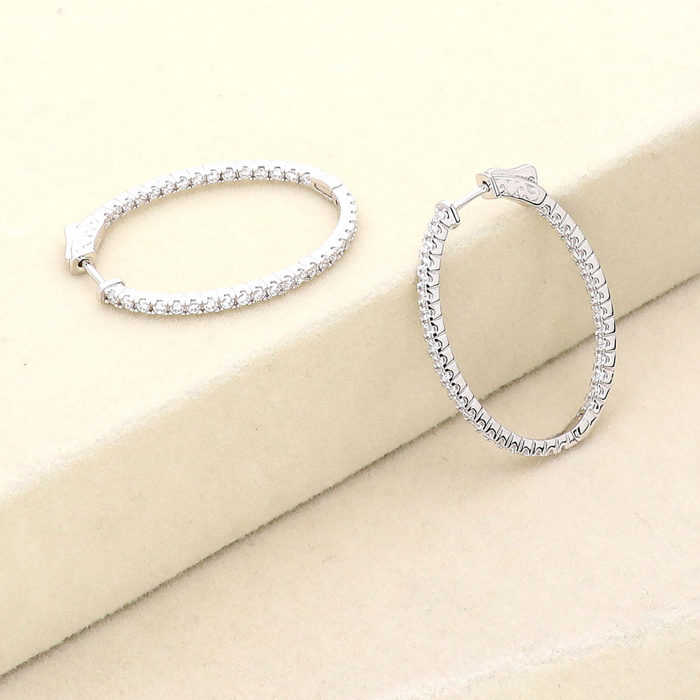 Flatlay view of Oval CZ Inside-Out Hoop Earrings in Sterling Silver 1.4 inch, Rhodium Plated