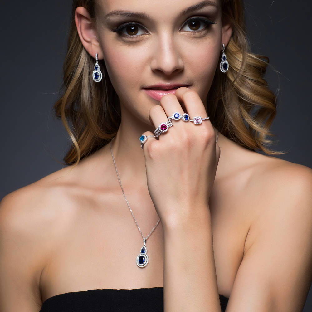 Model wearing Halo Simulated Blue Sapphire Oval CZ Necklace in Sterling Silver, 3 of 6