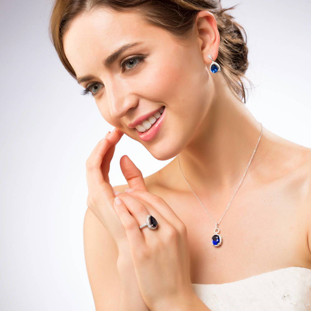 Model wearing Halo Simulated Blue Sapphire Oval CZ Necklace in Sterling Silver, 3 of 6