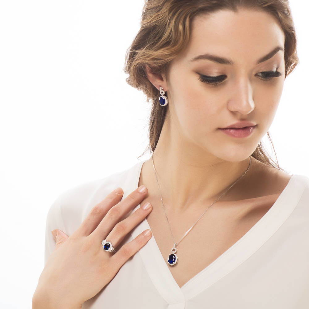 Model wearing Halo Simulated Blue Sapphire Oval CZ Necklace in Sterling Silver, 2 of 6