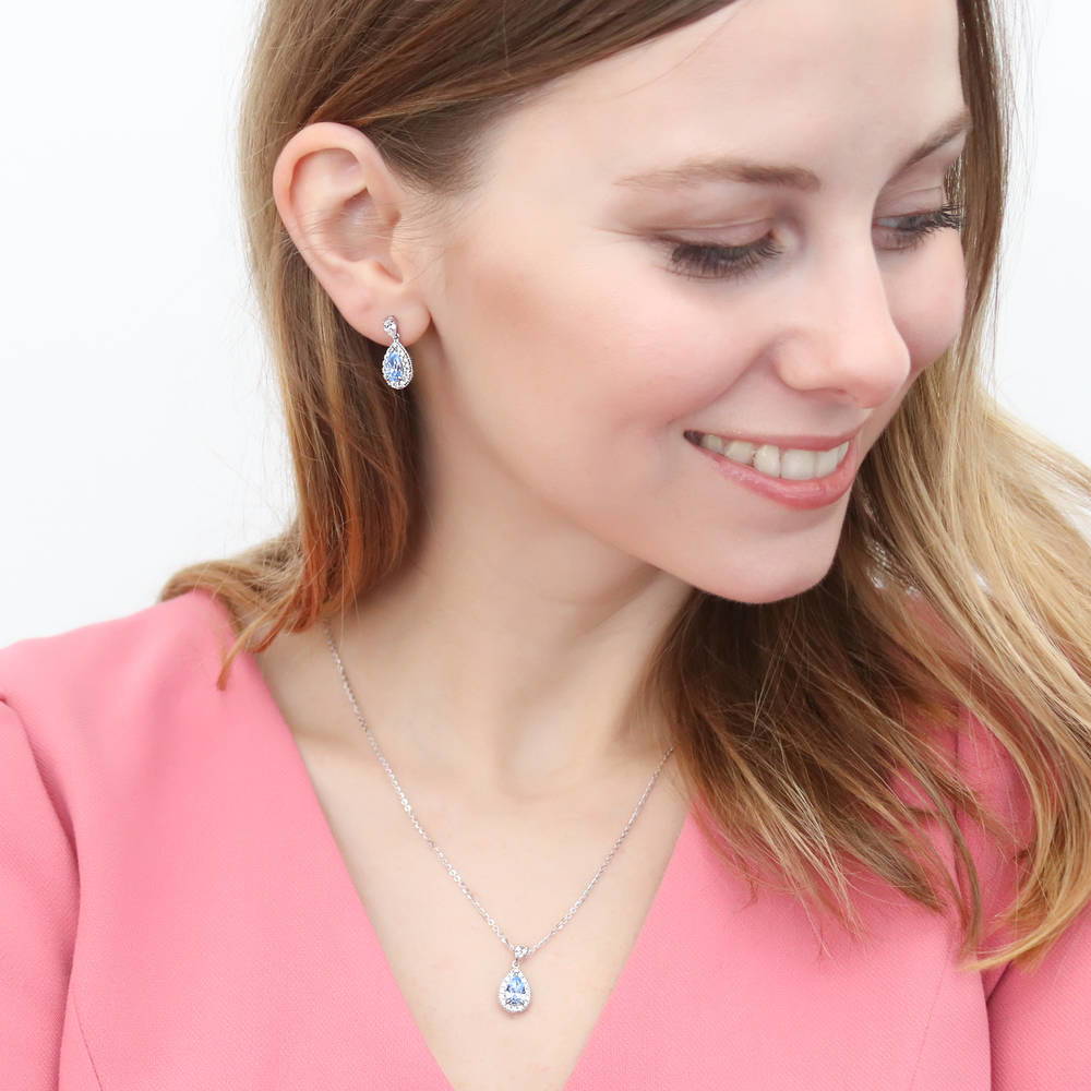 Model wearing Halo Pear CZ Earrings in Sterling Silver, Blue Color