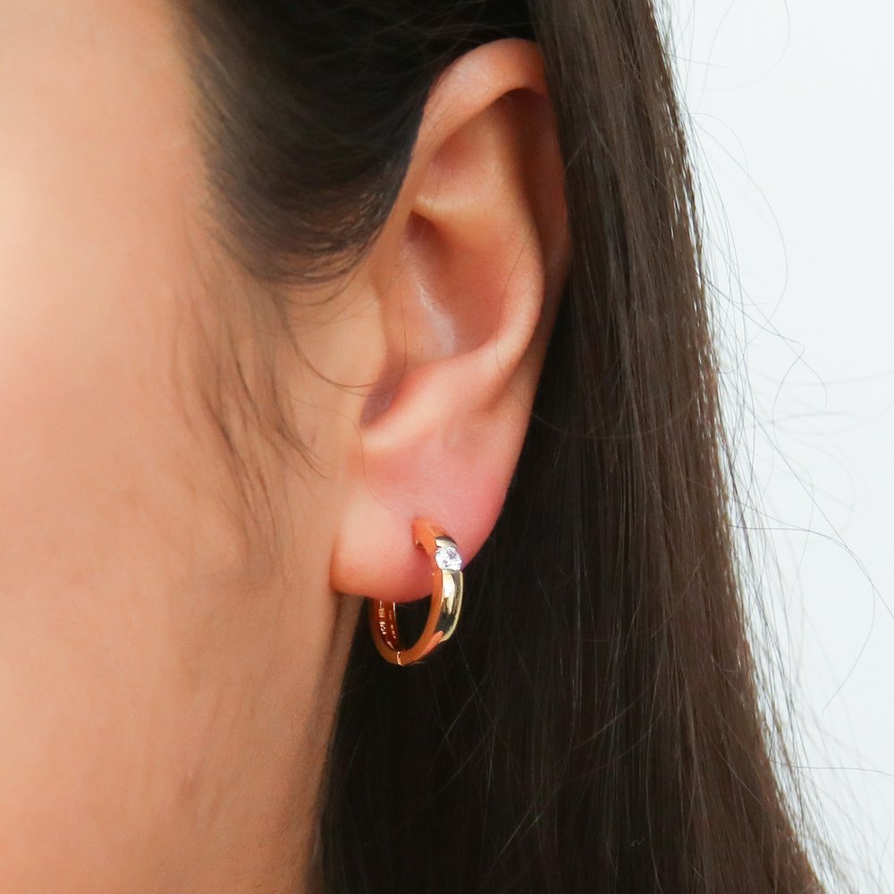 Model wearing Solitaire CZ Small Hoop Earrings in Sterling Silver 0.6 inch, Yellow Gold Flashed