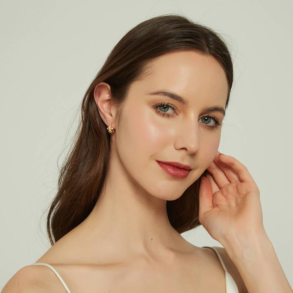Model wearing Fleur De Lis CZ Mini Huggie Earrings in Sterling Silver 0.5 inch, Rhodium Plated