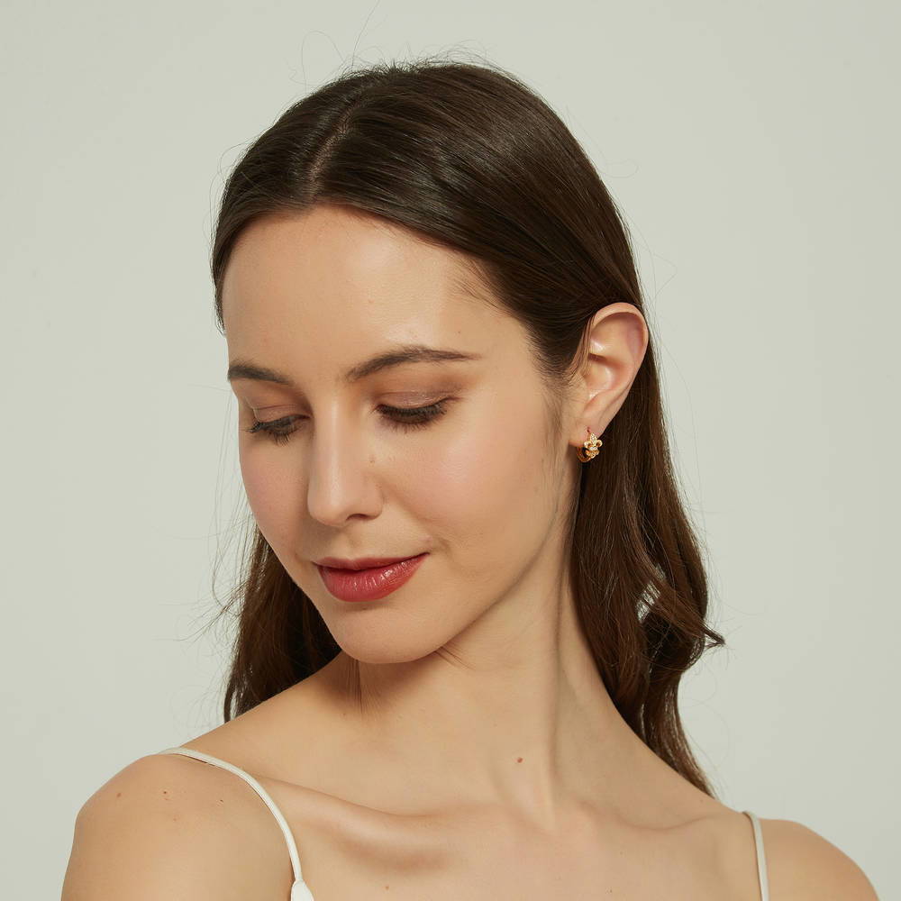 Model wearing Fleur De Lis CZ Mini Huggie Earrings in Sterling Silver 0.5 inch, Rhodium Plated