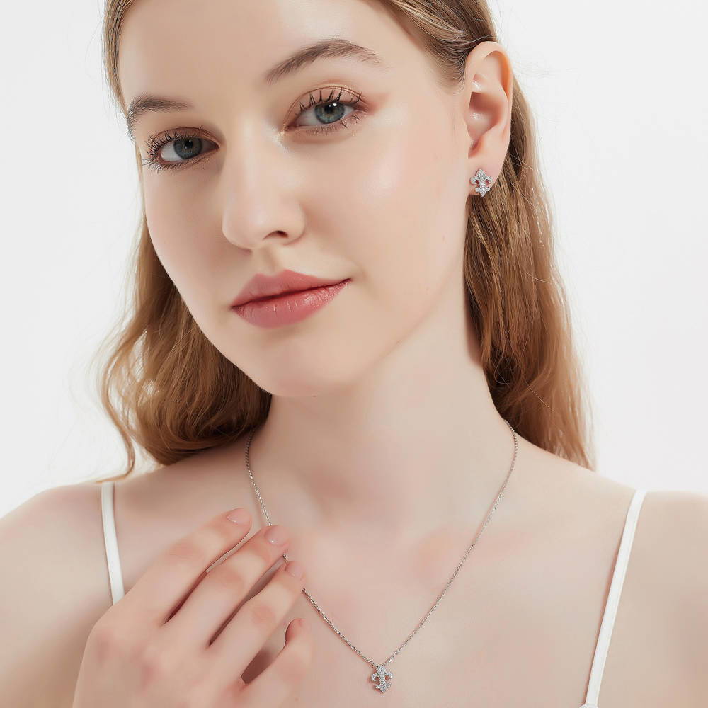 Model wearing Fleur De Lis CZ Necklace and Huggie Earrings Set in Sterling Silver, 14 of 16