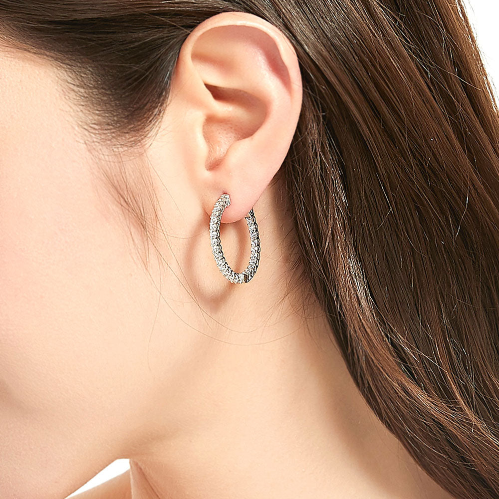 Model wearing CZ Small Inside-Out Hoop Earrings in Sterling Silver 1 inch, Rhodium Plated