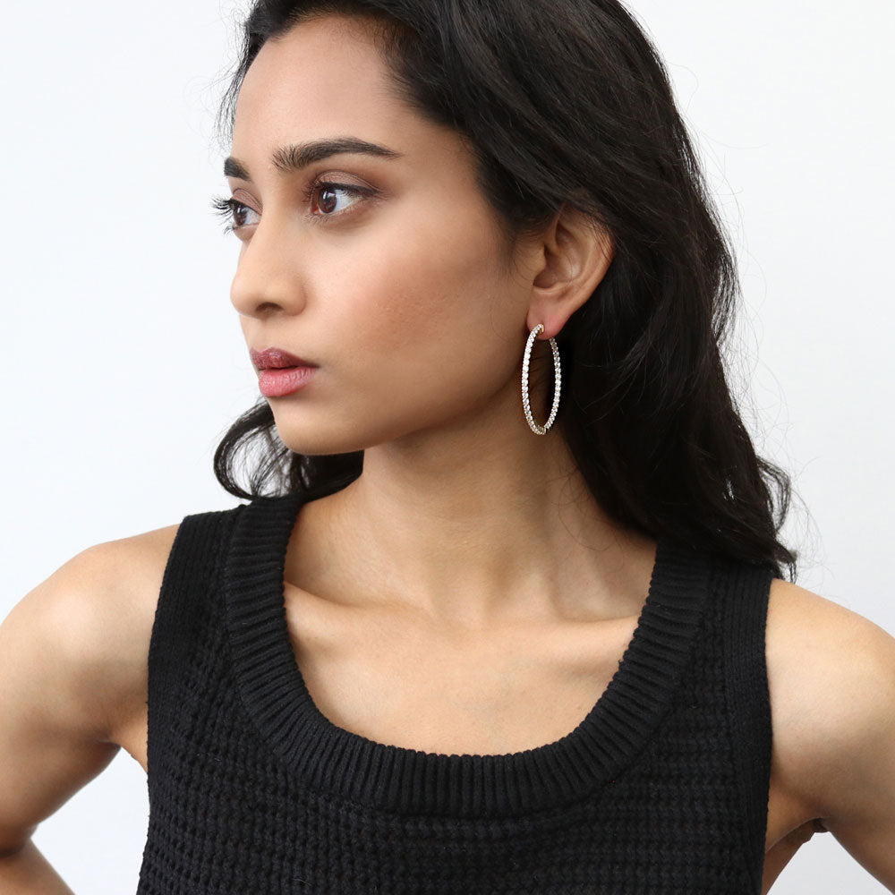 Model wearing CZ Inside-Out Hoop Earrings in Sterling Silver 1.8 inch, Yellow Gold Flashed