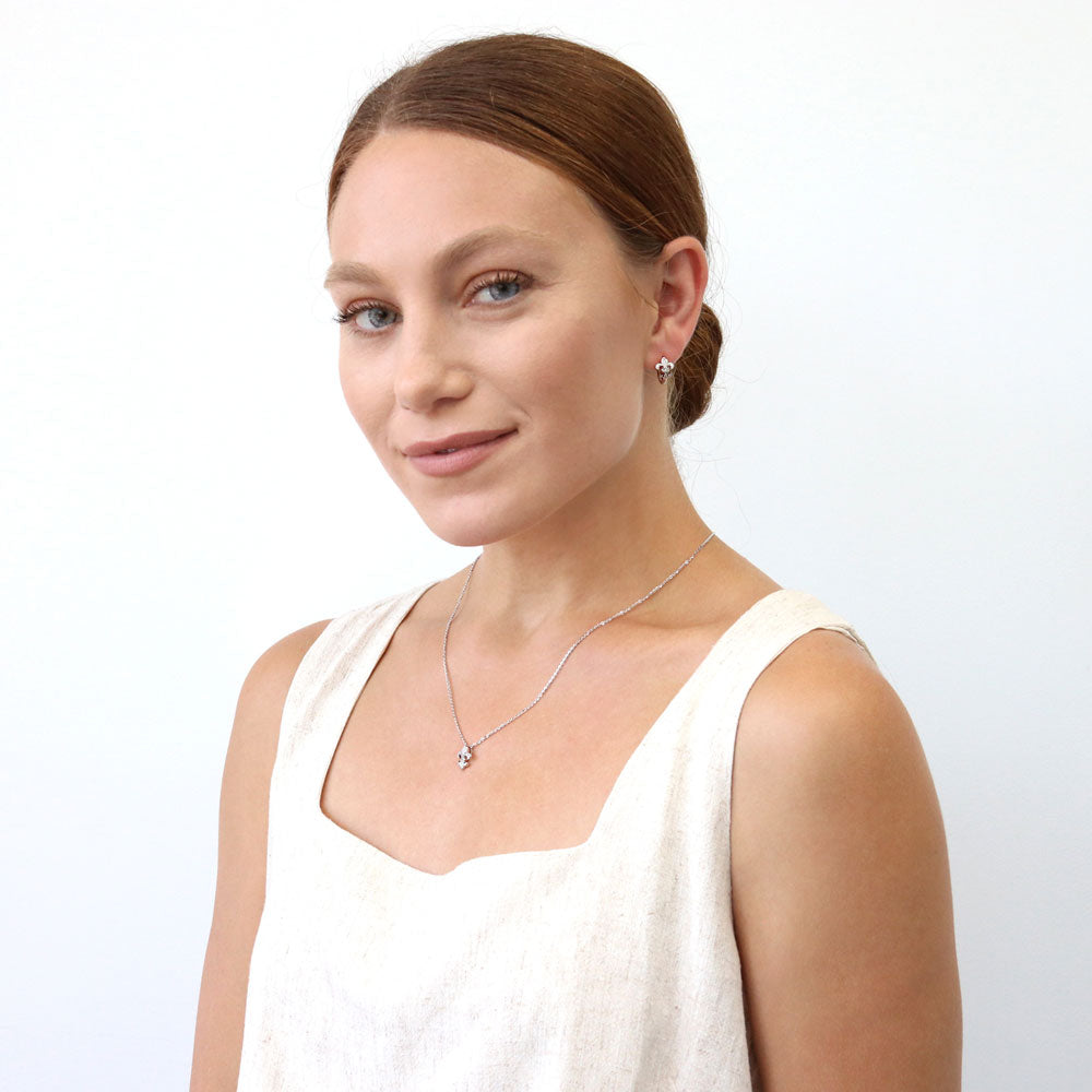 Model wearing Fleur De Lis CZ Mini Huggie Earrings in Sterling Silver 0.5 inch, Rhodium Plated