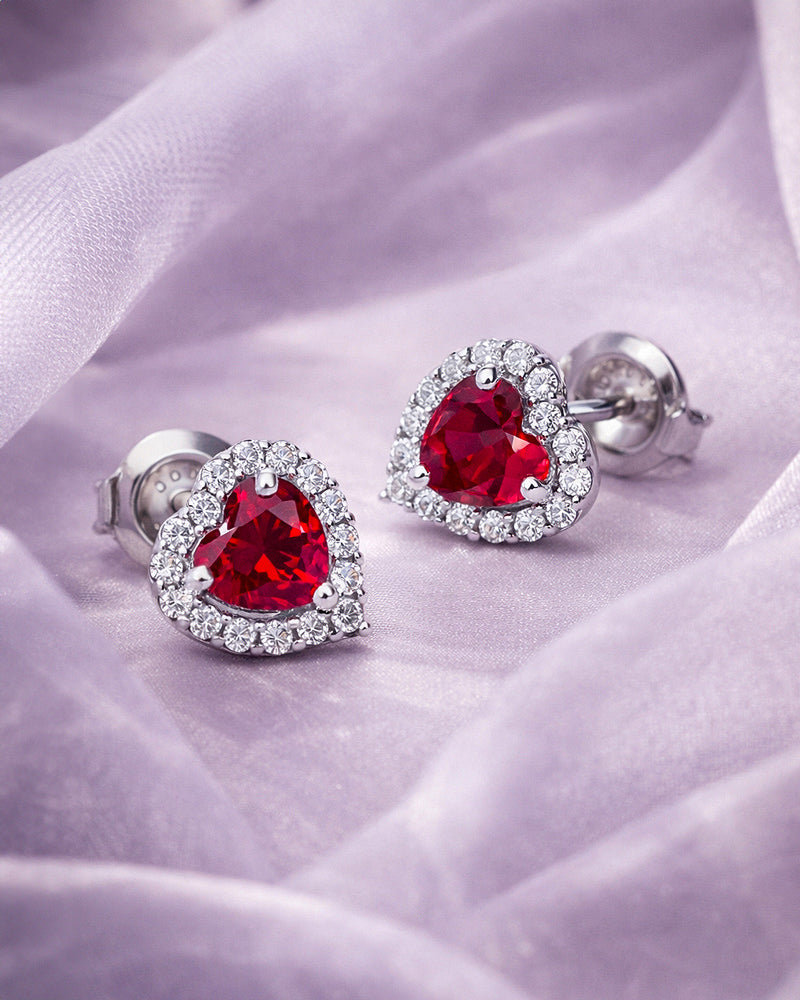 Red CZ earrings on a soft purple fabric background