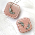 Flatlay view of Feather CZ Stud Earrings in Sterling Silver, Rhodium Plated