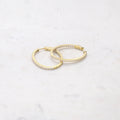 Flatlay view of Oval CZ Medium Inside-Out Hoop Earrings in Sterling Silver 1.4 inch, Yellow Gold Flashed