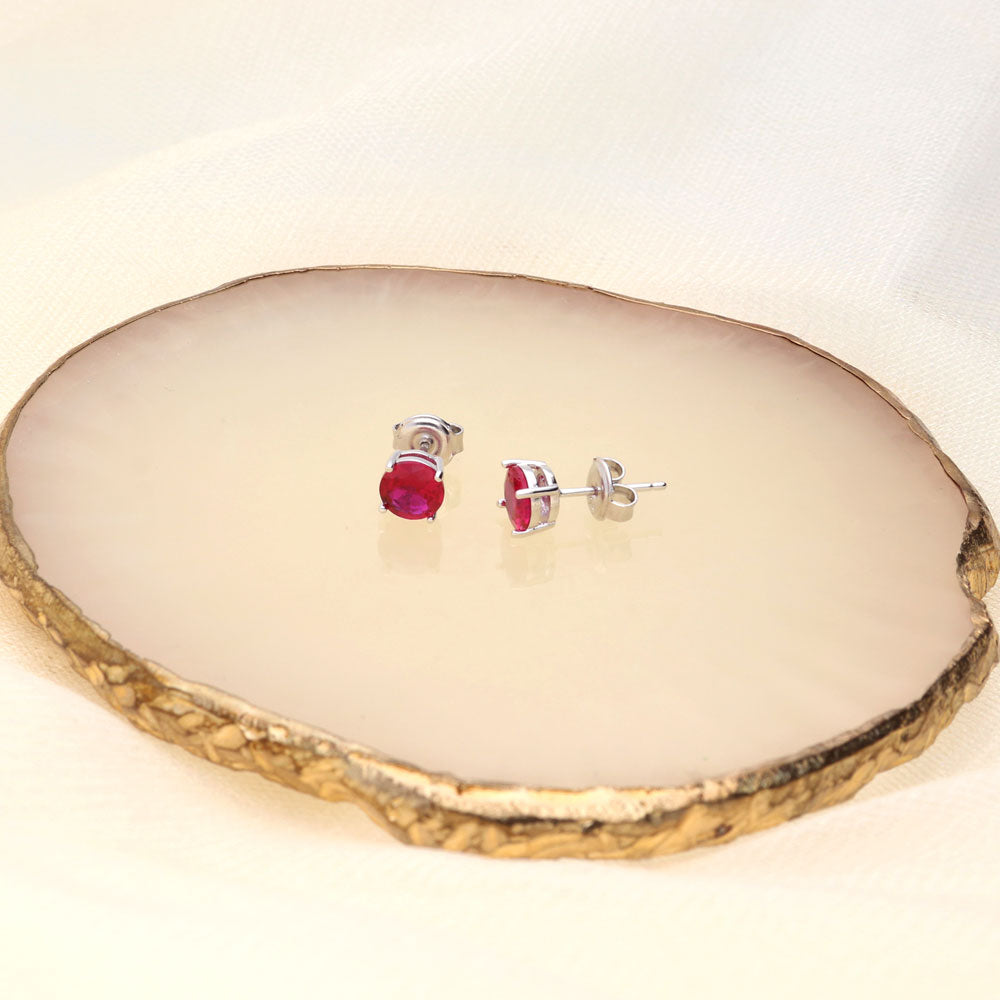 Flatlay view of Solitaire CZ Stud Earrings in Sterling Silver 1.6ct, Ruby Color