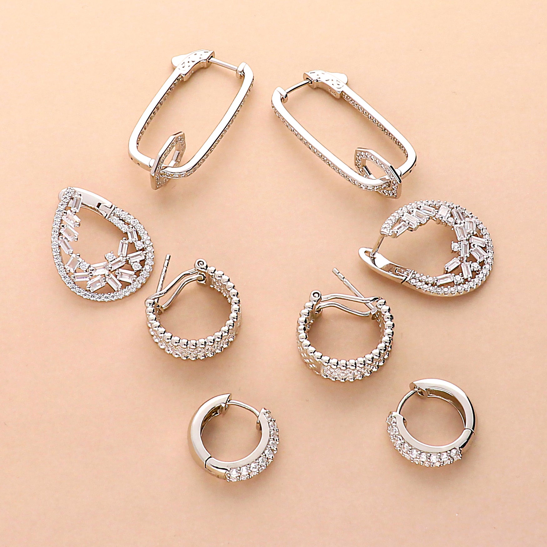 Collection of hoop and huggie earrings featuring different shapes, sizes, and cubic zirconia embellishments.