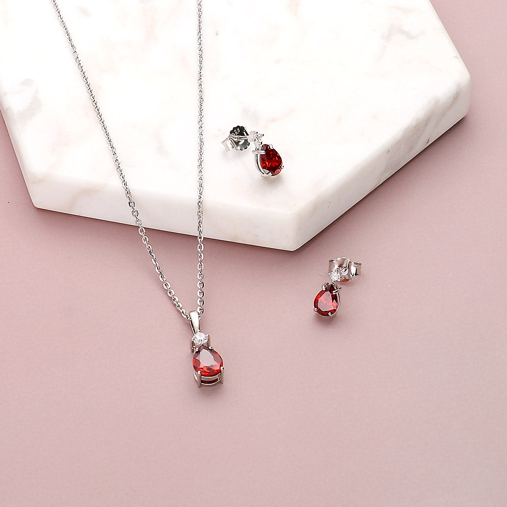 Flatlay view of Solitaire 2-Stone 1.4ct Pear CZ Stud Earrings in Sterling Silver, Garnet Color
