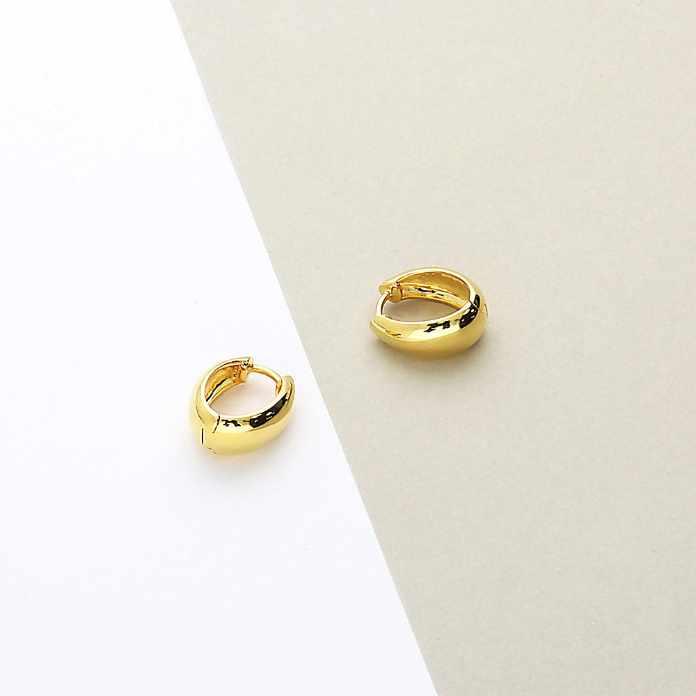 Flatlay view of Oval Dome Small Huggie Earrings in Sterling Silver 0.6 inch, Yellow Gold Flashed