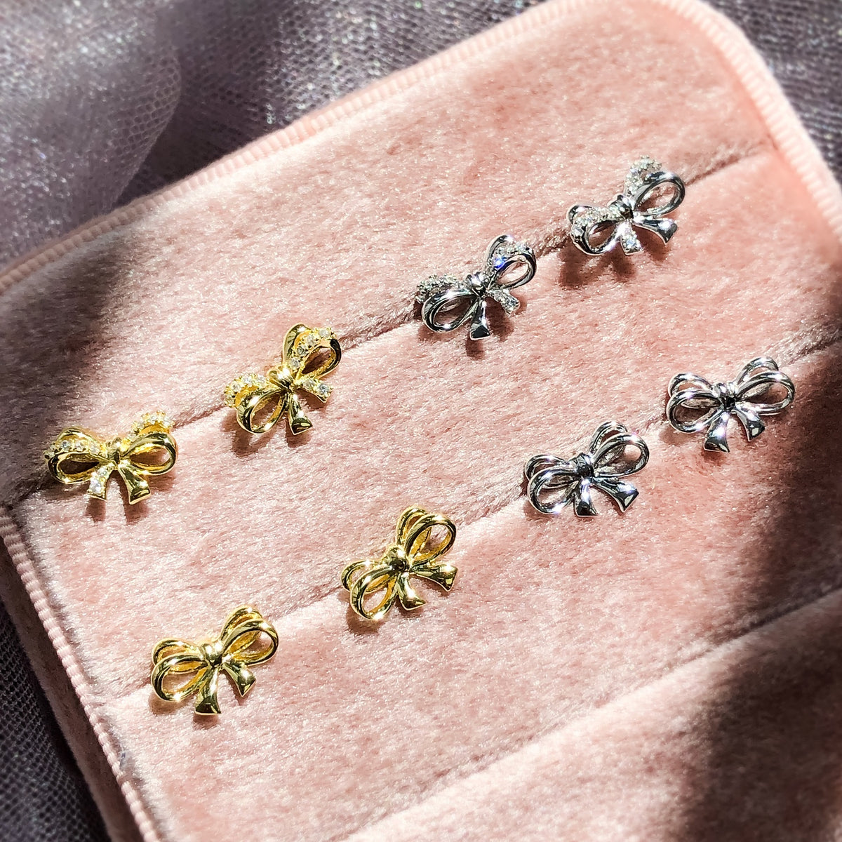 Flatlay view of Bow Tie Ribbon CZ Stud Earrings in Gold Flashed Sterling Silver