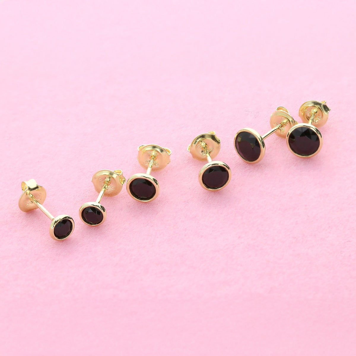 Flatlay view of Martini Solitaire Bezel CZ Stud Earrings, Gold Flashed, Black / 4mm