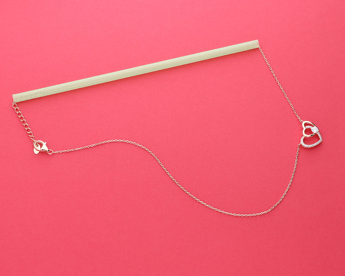 Heart necklace threaded through a straw to keep the chain untangled during storage.