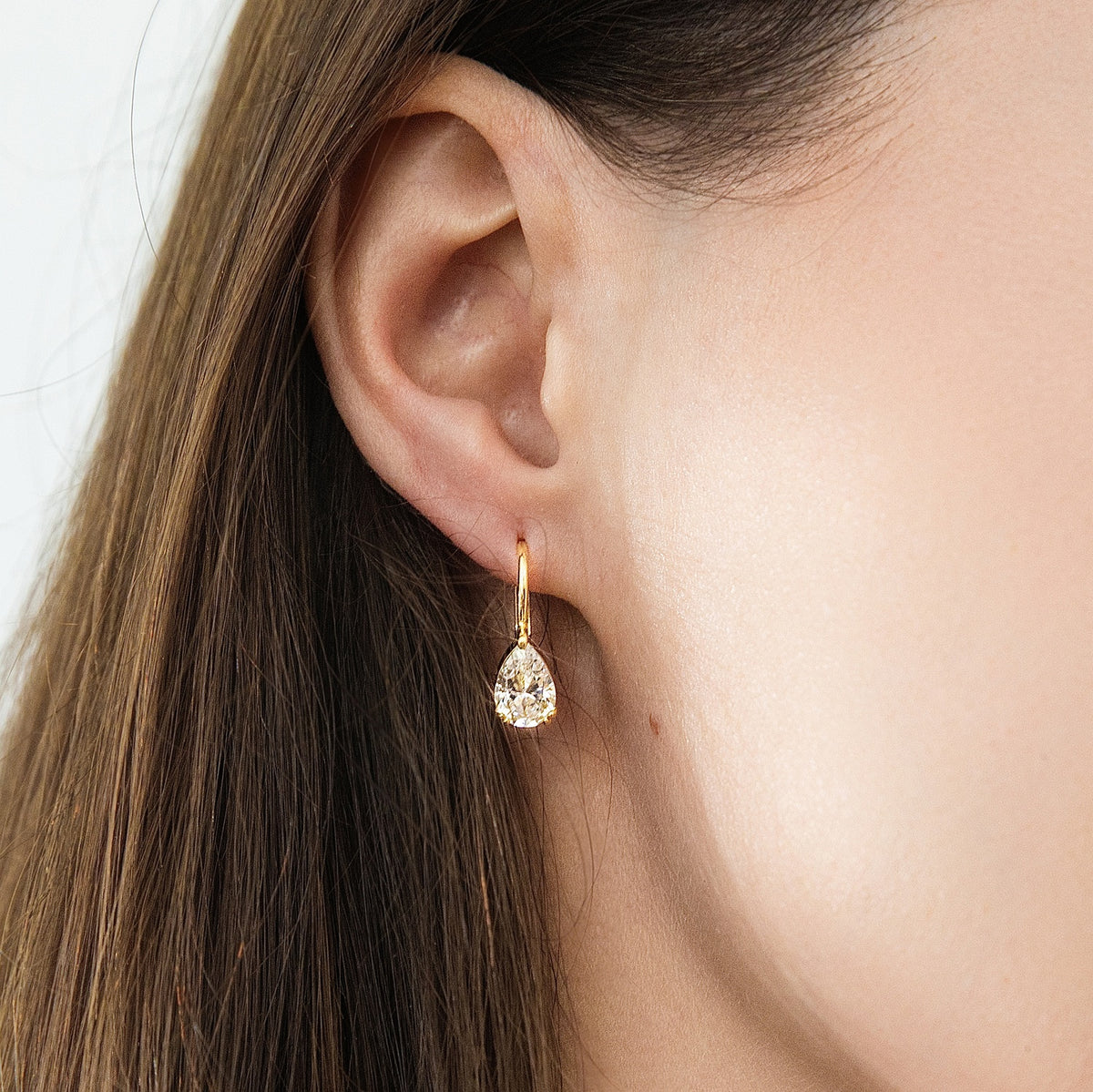 Model wearing Solitaire 1.6-2.6ct Pear CZ Leverback Earrings in Sterling Silver, Clear, Gold Flashed