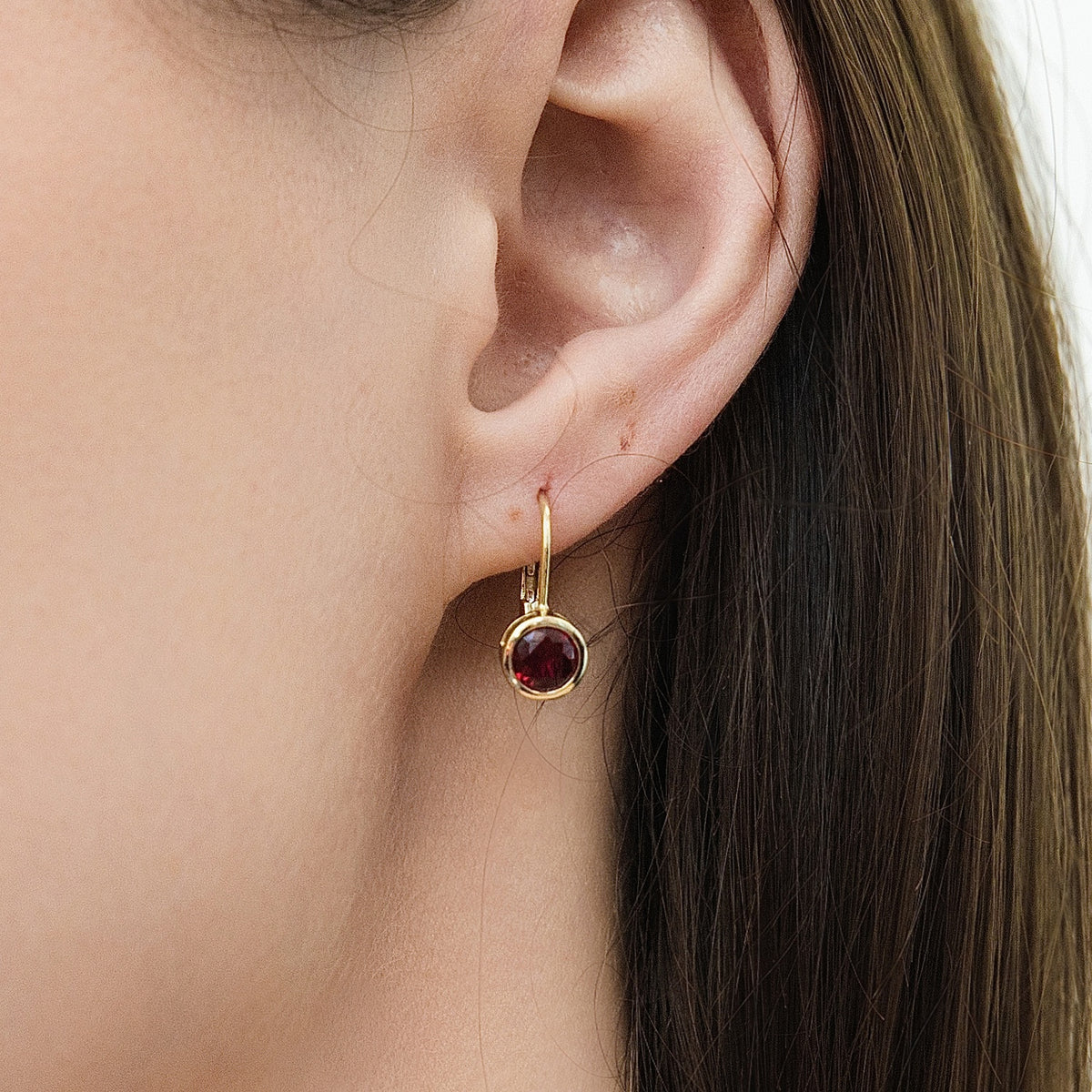 Model wearing Solitaire 1.2ct Bezel CZ Leverback Earrings in Sterling Silver, Ruby, Gold Flashed