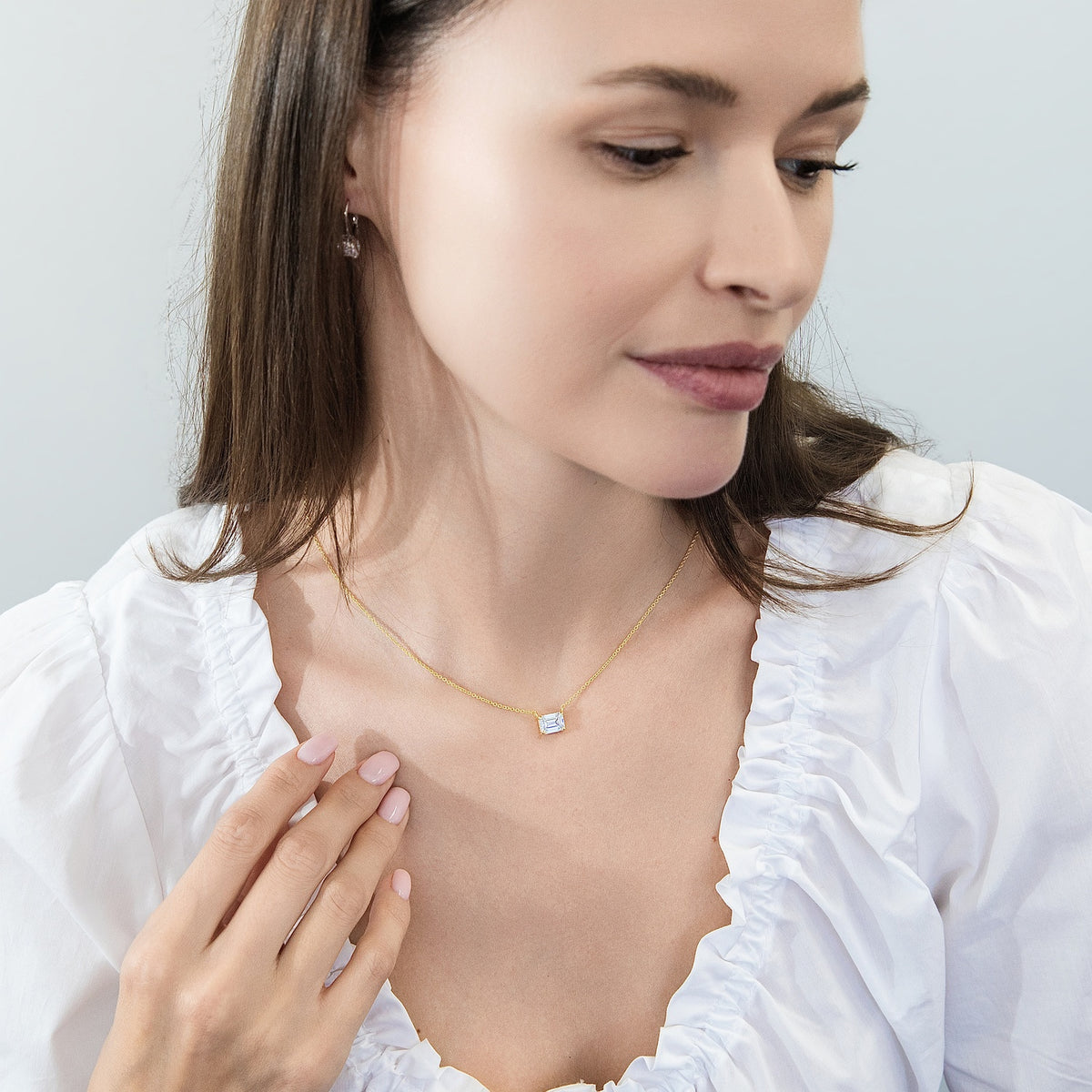 Model wearing Solitaire East-West Emerald Cut CZ Necklace in Sterling Silver, Gold Flashed