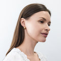 Model wearing Dome Mini Huggie Earrings 0.5 inch, Gold Flashed