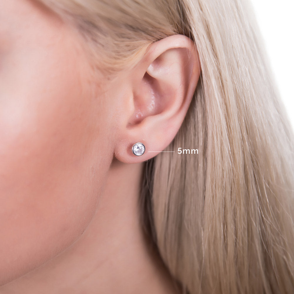 Model wearing Martini Solitaire Bezel CZ Stud Earrings, Rhodium Plated, Clear / 5mm