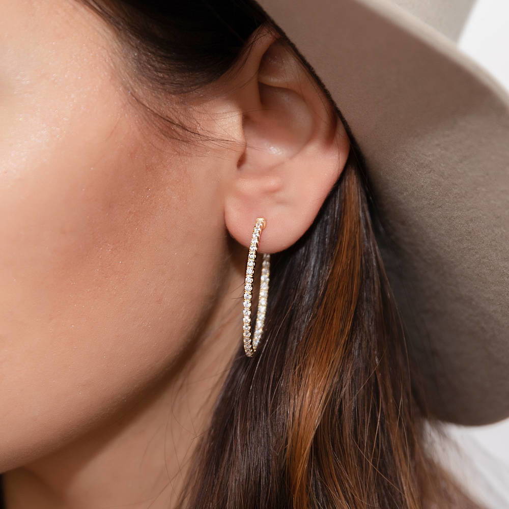 Model wearing Oval CZ Medium Inside-Out Hoop Earrings in Sterling Silver 1.4 inch, Yellow Gold Flashed