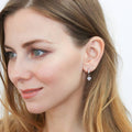 Model wearing Solitaire CZ Cartilage Huggie Earrings in Sterling Silver 0.5 inch, Rhodium Plated / Heart Shaped Cut