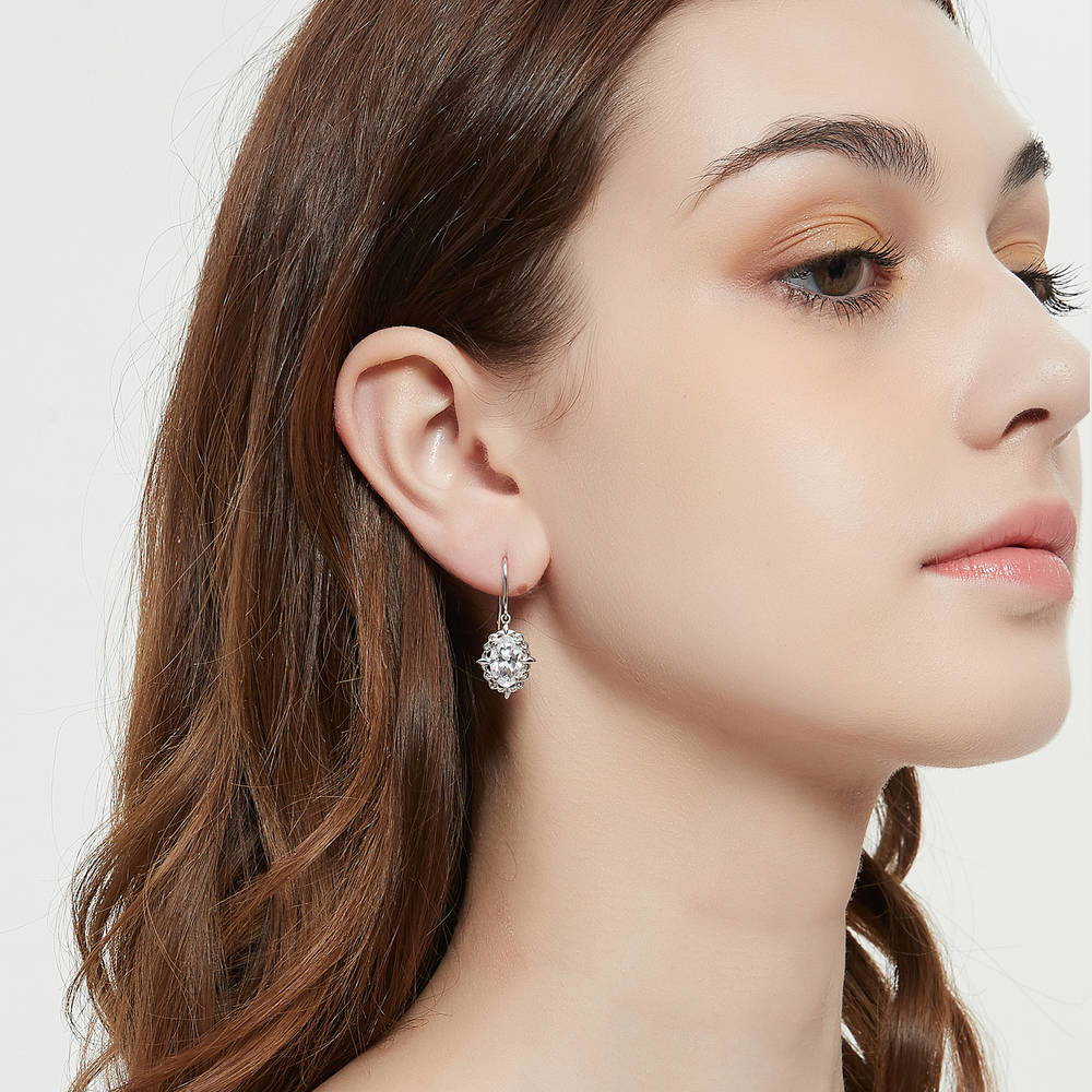 Model wearing Solitaire Filigree Oval CZ Fish Hook Earrings in Sterling Silver, 3 of 7