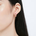 Model wearing Dome Small Huggie Earrings in Sterling Silver 0.55 inch, Rose Gold Flashed