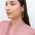 Model wearing CZ Large Inside-Out Hoop Earrings in Sterling Silver 2.5 inch, Rhodium Plated