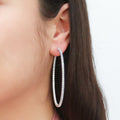 Model wearing CZ Large Inside-Out Hoop Earrings in Sterling Silver 2.5 inch, Rhodium Plated