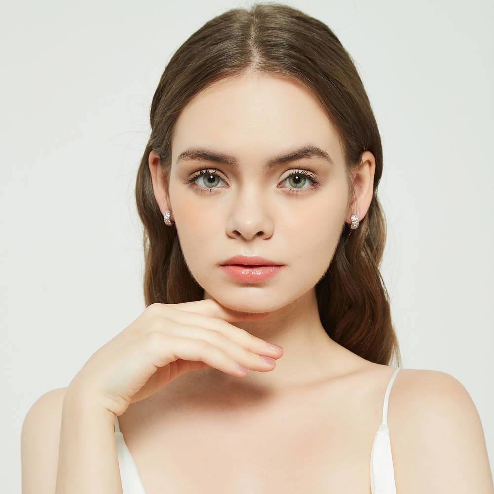 Model wearing CZ Small Huggie Earrings in Sterling Silver 0.5 inch, Morganite Color