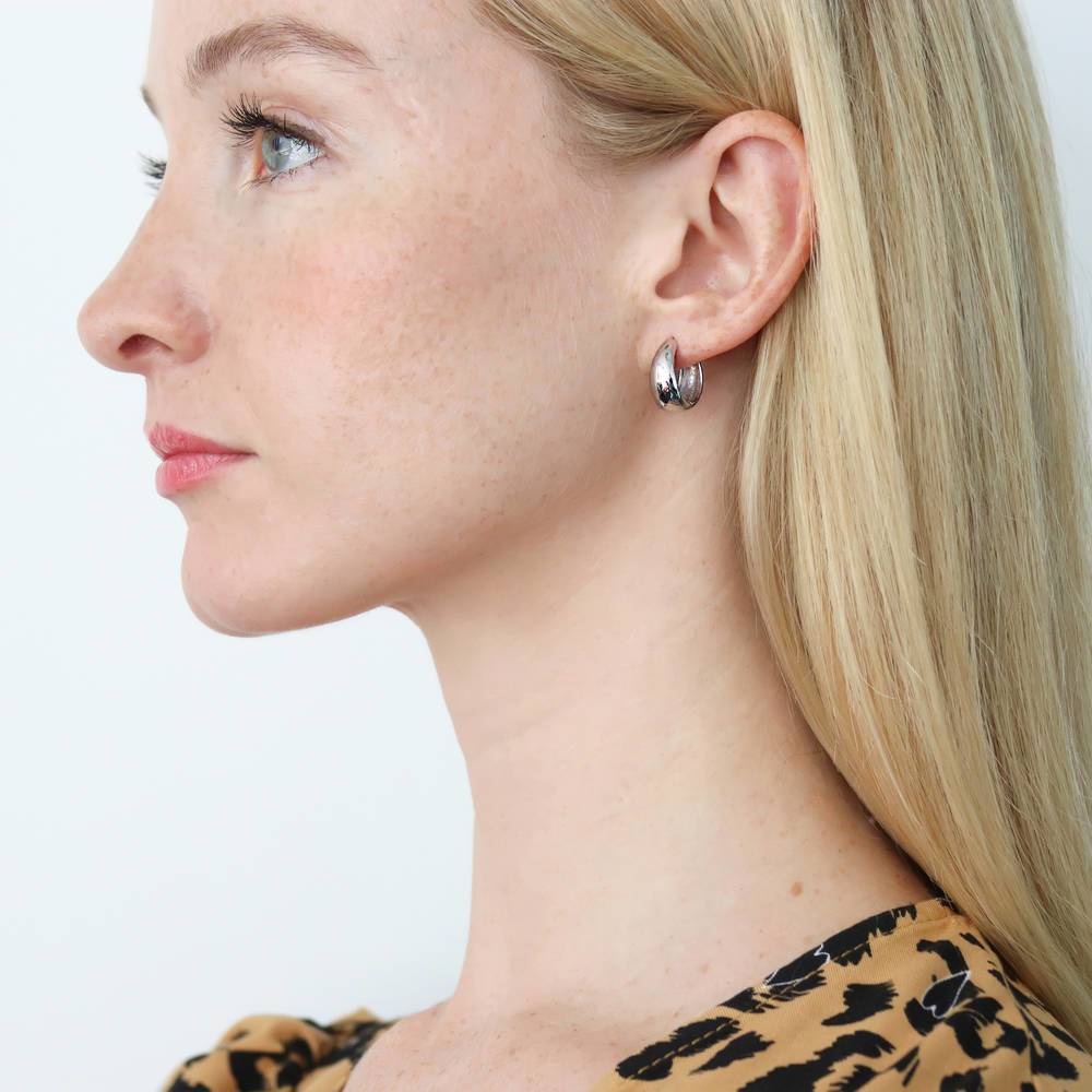 Model wearing Oval Dome Small Huggie Earrings in Sterling Silver 0.6 inch, Rhodium Plated