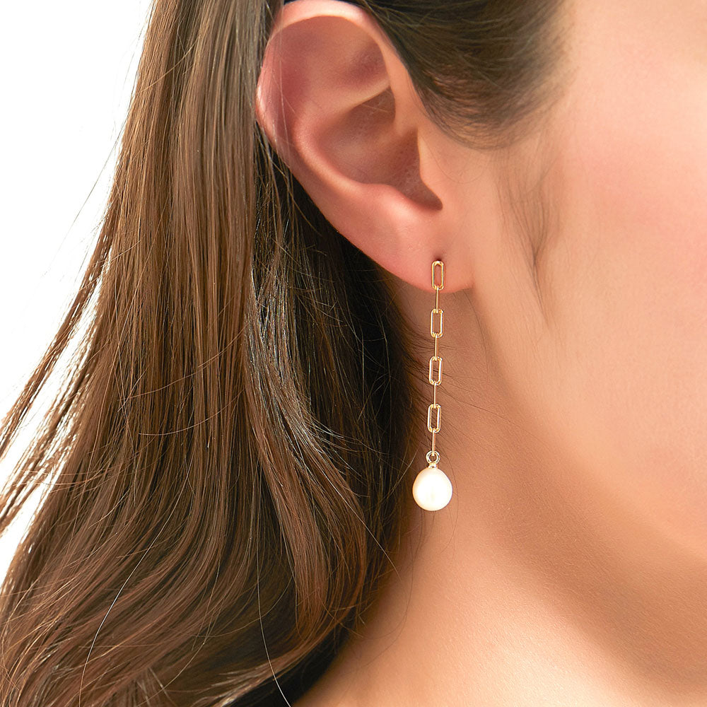 Model wearing Solitaire Oval Cultured Pearl Earrings in Sterling Silver, Yellow Gold Flashed