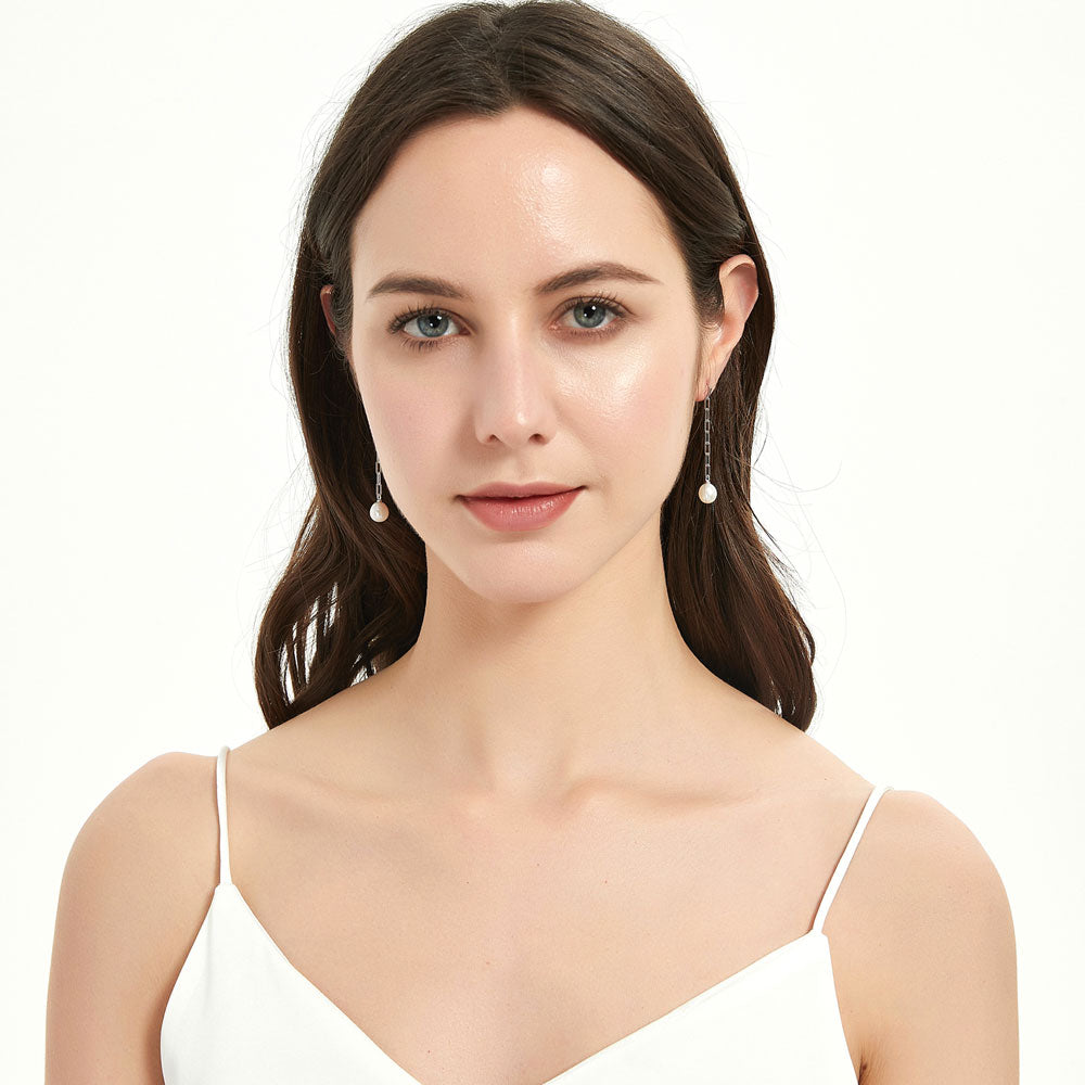 Model wearing Solitaire Oval Cultured Pearl Earrings in Sterling Silver, Yellow Gold Flashed