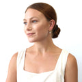 Model wearing Solitaire CZ Cartilage Huggie Earrings in Sterling Silver 0.5 inch, Yellow Gold Flashed / Round Cut