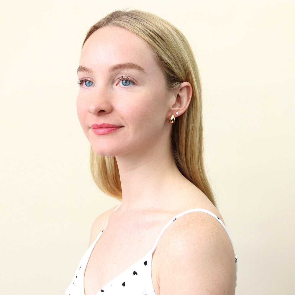Model wearing Dome CZ Small Huggie Earrings in Sterling Silver 0.6 inch, Yellow Gold Flashed